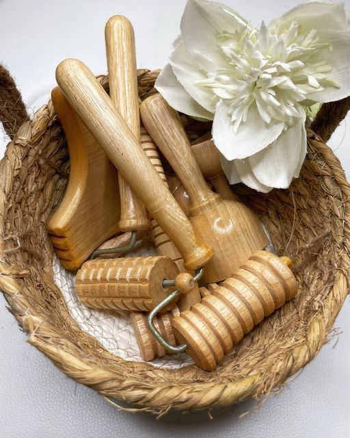 Un panier d'outils de madérothérapie en bois et une fleur blanche.