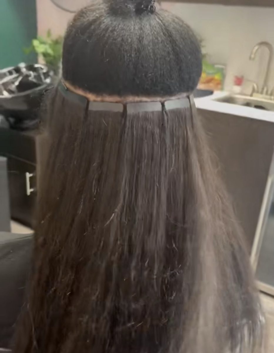 Une rangée d'extensions tape-in posée à la racine, vue de dos.