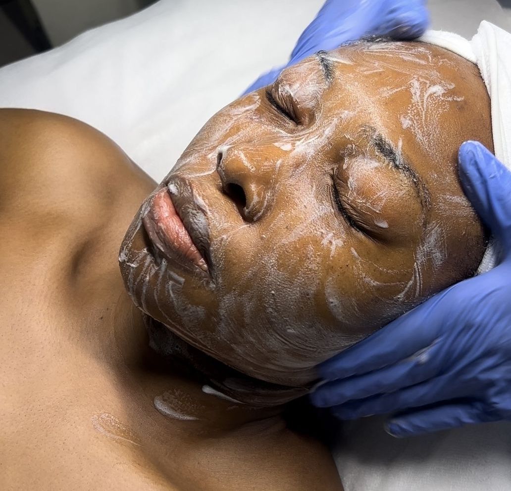 Un massage du visage, les mains gantées de bleu.